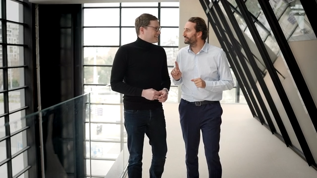 Two men talking and walking outside the office