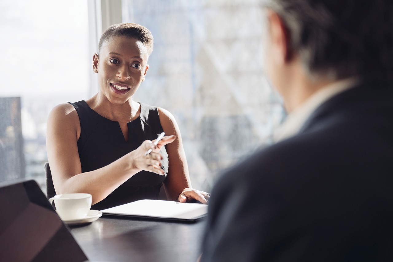 Une femme assise à une table donnant des conseils à un homme