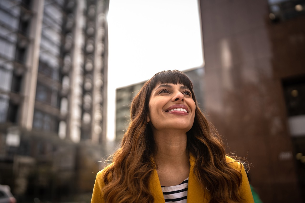 Woman smiling in the street and looking up